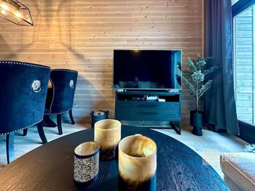 sala de estar con mesa y TV de pantalla plana en New high standard apartment in Trysil alpine lodge, en Trysil