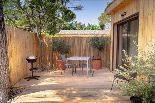 a wooden deck with a table and chairs on it at Chalet détente proche plage in La Ciotat