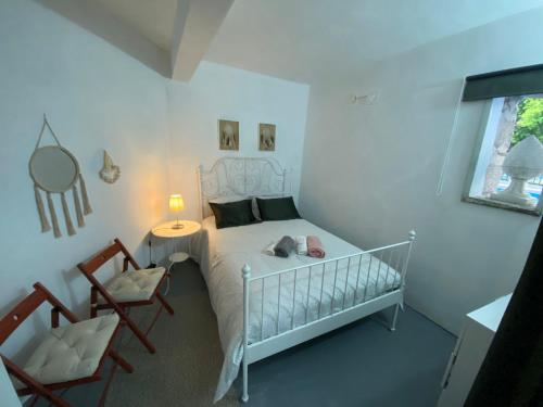 Cidadelhe的住宿－Casa Cecí Douro，一间卧室配有一张婴儿床和两把椅子