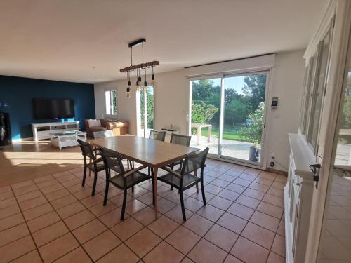 une salle à manger avec une table et des chaises et un salon dans l'établissement La maison dans la colline, à Velleron