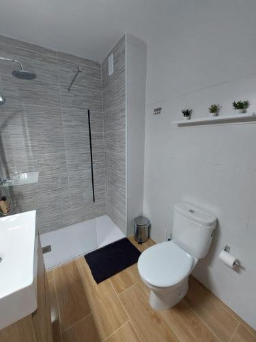 a white bathroom with a toilet and a shower at Comodoro Los Cristianos 601T in Los Cristianos