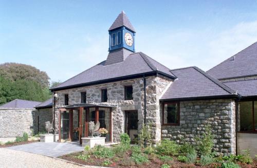 a building with a clock tower on top of it at Tre-Ysgawen Hall & Spa in Llangefni