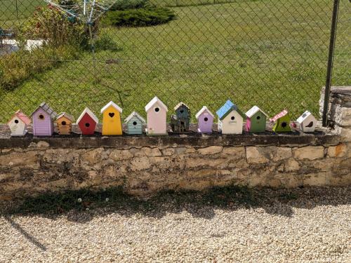 a row of colorful bird houses on a stone wall at Les Jolis Nids - Studio Moineau in La Roche-Posay