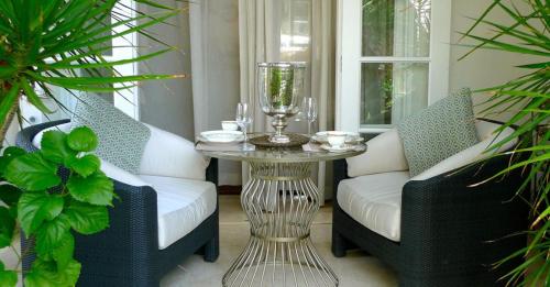 a porch with two chairs and a table with a glass centerpiece at Sunny Vacation Villa No 18 in Saint Peter