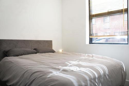 - une chambre avec un grand lit blanc et une fenêtre dans l'établissement Salford, Manchester, à Manchester