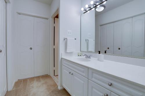 a white bathroom with a sink and a mirror at Luxury condo @Crystal City with Amazing Amenities in Arlington