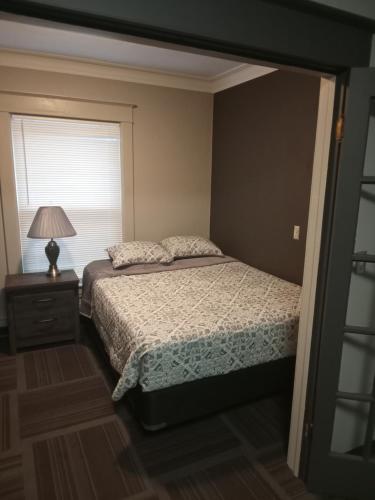 - une chambre avec un lit, une lampe et une fenêtre dans l'établissement E. Michigan Walk Up Furnished 2 Bedroom APT, à Lansing
