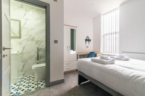 een slaapkamer met een bed en een badkamer met een douche bij 2BR Derby City Centre Flat 3 - Charnwood Flat in Derby