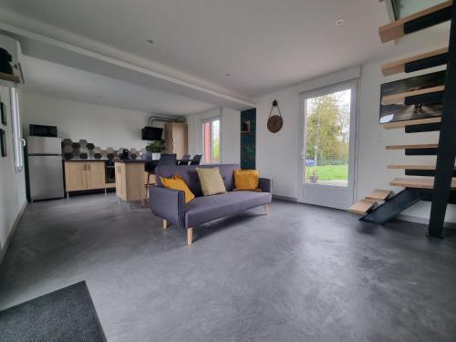 a living room with a couch and a kitchen at Les terres de Marie - Logements calmes et modernes in La Haye-en-Lyons