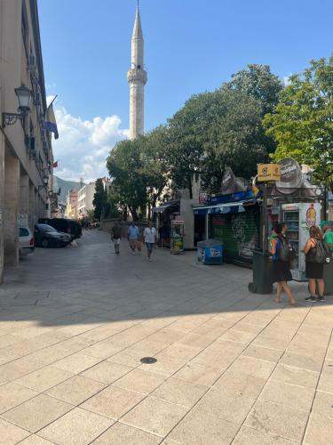 una calle de la ciudad con una torre de reloj en la distancia en Mostar Dream, en Mostar