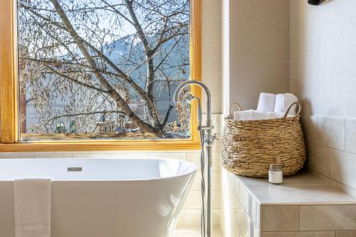 a bathroom with a bath tub and a window at Brewster Mountain Lodge in Banff