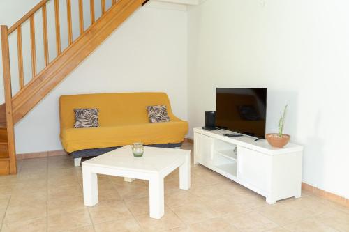 a living room with a couch and a coffee table at Villa au calme avec Jacuzzi, Villa Le Boursoie in Les Abymes