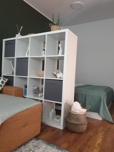 a white book shelf in a room with a bed at Apartma Thermos in Krapinske Toplice