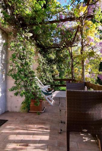 a patio with a table and chairs and trees at La Traversina in Stazzano