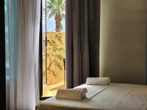 1 dormitorio con cama y vistas a un balcón en Charm Hotel en Vlorë