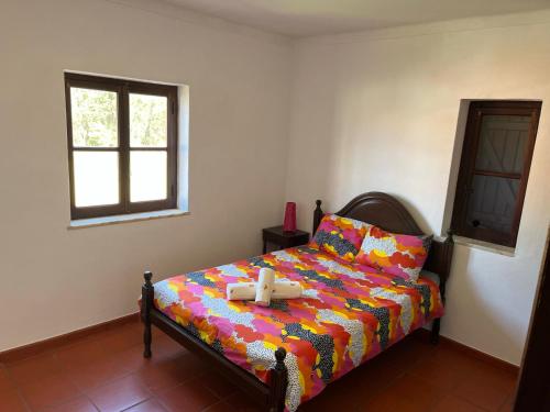 1 dormitorio con 1 cama con un edredón colorido en A place in the sun, en Longueira