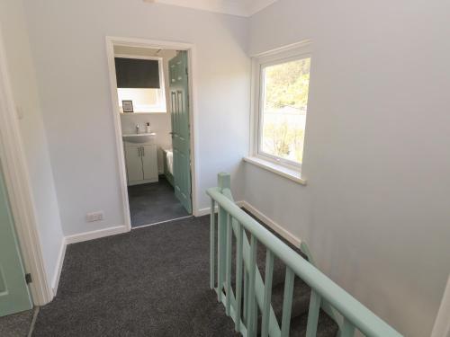 a room with a staircase with a window and a sink at Afan House in Port Talbot