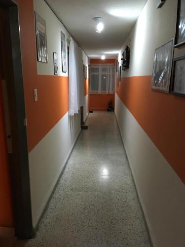 a hallway in a hospital with orange and white walls at Private room with air conditioning in Downtown Office Parking in León