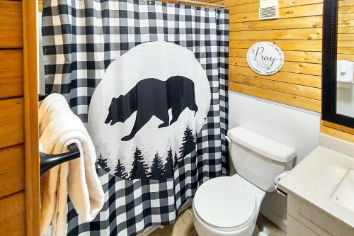 a bathroom with a bear shower curtain in a cabin at Mountain Top Retreat in Gatlinburg