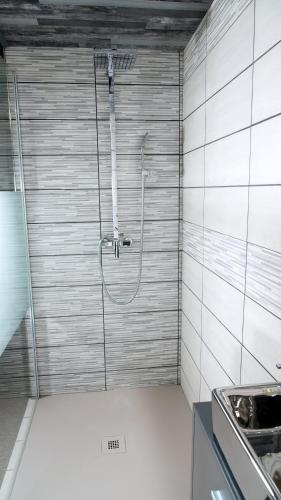 a shower in a bathroom with a tile wall at La Sapinière St Lary Soulan in Saint-Lary-Soulan