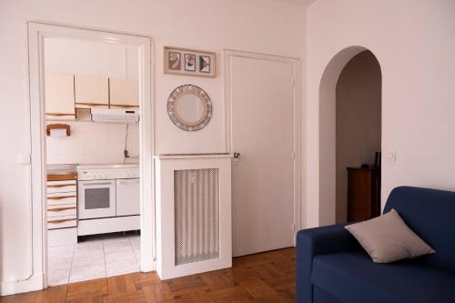 un salon avec un canapé bleu et une cuisine dans l'établissement Le Grand Sud, à Nice