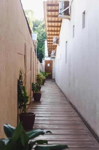 an alley with potted plants on the sides of buildings at Pousada Aconchego Noronha in Fernando de Noronha