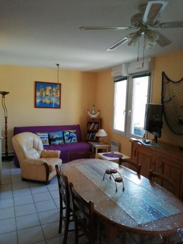 un salon avec une table et un canapé dans l'établissement Maison ensoleillée pour 4 à 6 pers, à Saint-Georges-de-Didonne