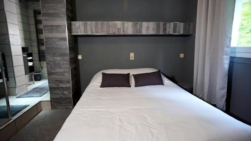 a bed with two pillows on it in a bedroom at La Sapinière St Lary Soulan in Saint-Lary-Soulan