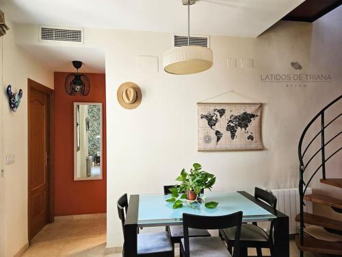 Un comedor con una mesa y sillas azules. en Latidos de Triana - ático con vistas a todo Sevilla, en Sevilla