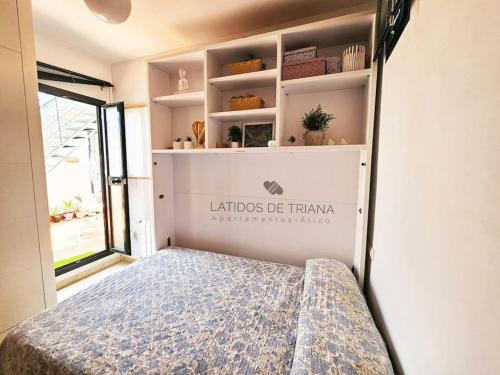 een kleine slaapkamer met een bed in een kamer bij Latidos de Triana - ático con vistas a todo Sevilla in Sevilla