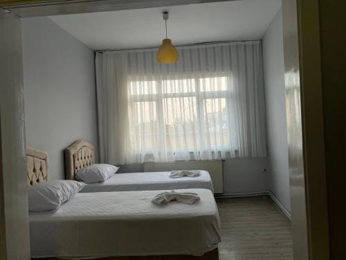 - une chambre avec 2 lits avec des draps blancs et une fenêtre dans l'établissement Sultanahmet Corner Apart, à Istanbul