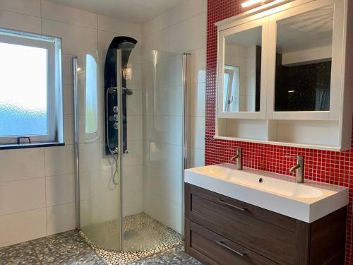 a bathroom with a shower and a sink and a mirror at Villalägenhet i Askim med havsutsikt in Gothenburg