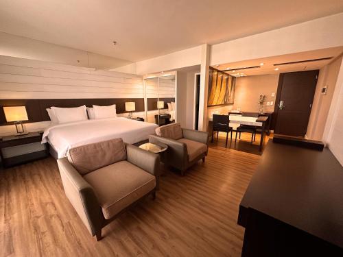a hotel room with a bed and a couch and a desk at Kubitschek Plaza Hotel in Brasilia