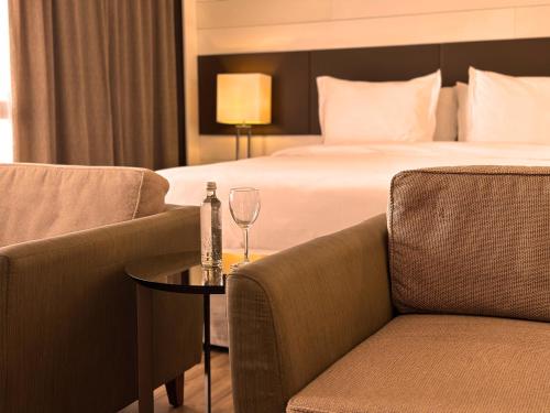 a hotel room with a bed and two chairs and a table at Kubitschek Plaza Hotel in Brasilia
