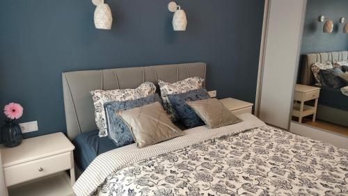 a bedroom with a bed with blue walls and pillows at Apartament Azul in Cieszyn