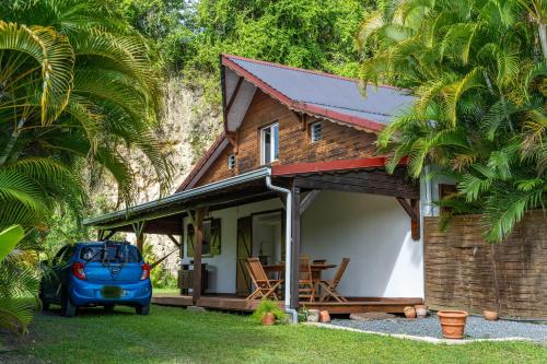 a house with a car parked in front of it at Villa au calme avec Jacuzzi, Villa Le Boursoie in Les Abymes