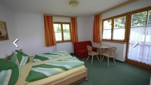 1 Schlafzimmer mit 2 Betten, einem Tisch und einem Stuhl in der Unterkunft Ferienhof Jugendherberge Wurm in Stummerberg