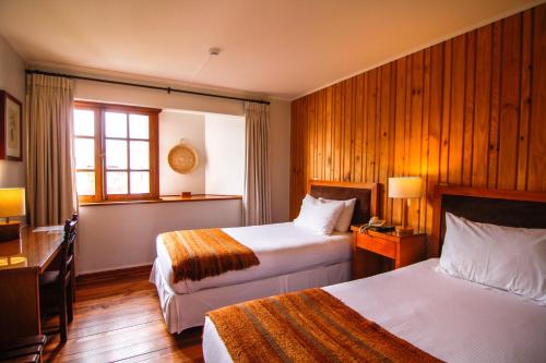 a hotel room with two beds and a window at Hotel Costanera - Caja Los Andes in Valdivia