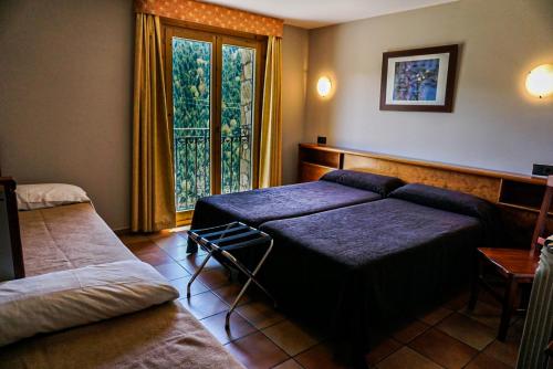 1 dormitorio con 2 camas y ventana grande en Hotel Ransol, en El Tarter