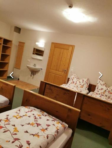 Zimmer mit einem Bett und einem Waschbecken in einem Zimmer in der Unterkunft Ferienhof Jugendherberge Wurm in Stummerberg