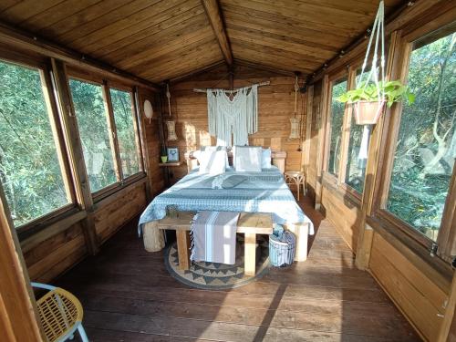 a bedroom in a log cabin with a bed in it at The Treehouse - Casa sull'albero al Golden Camp in Falerna