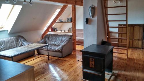 a living room with a couch and a table and a stove at Agroturystyka Mazury Cicha Wólka in Zawady