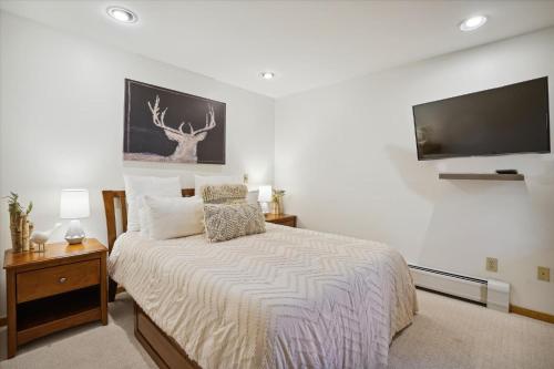 1 dormitorio con 1 cama y TV de pantalla plana en One bedroom condo with Sports Center, Shuttle service Highridge I10, en Killington