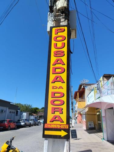a yellow and orange sign on the side of a building at Pousada da Dora in Prado