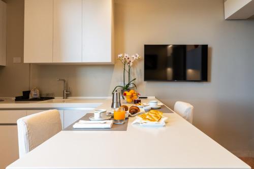 a kitchen with a white table with chairs and a white table sidx sidx at Residence Oliveto in Ceriale