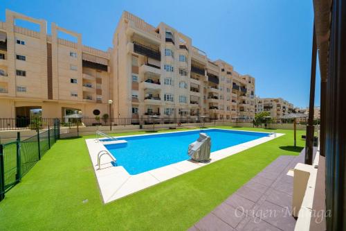 an apartment with a swimming pool in front of a building at Teatinos Paradise in Málaga