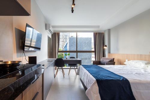 Pokój hotelowy z łóżkiem i biurkiem w obiekcie Rooftop #504 - Suíte confortável na Praia de Boa Viagem por Carpediem w mieście Recife