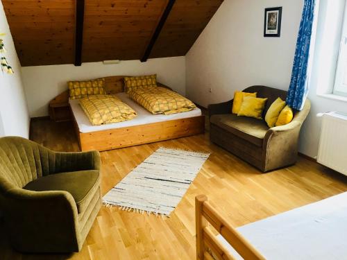 ein Wohnzimmer mit einem Bett und 2 Stühlen in der Unterkunft Haus Martina in Ehrwald