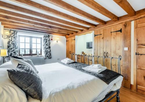 1 dormitorio con cama grande y techo de madera en Knipe Fold Barn en Hawkshead