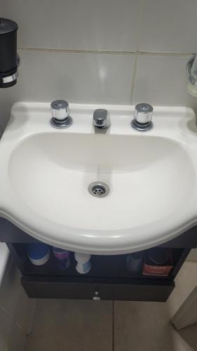 a white sink with two knobs on top of it at VGC hospedaje tranquilo a 5 min del aeropuerto pet friendly in Ezeiza